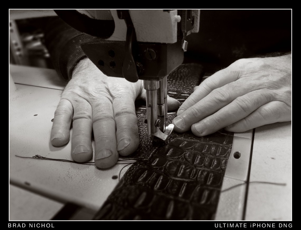 Industrial sewing machine sewing embossed leather.