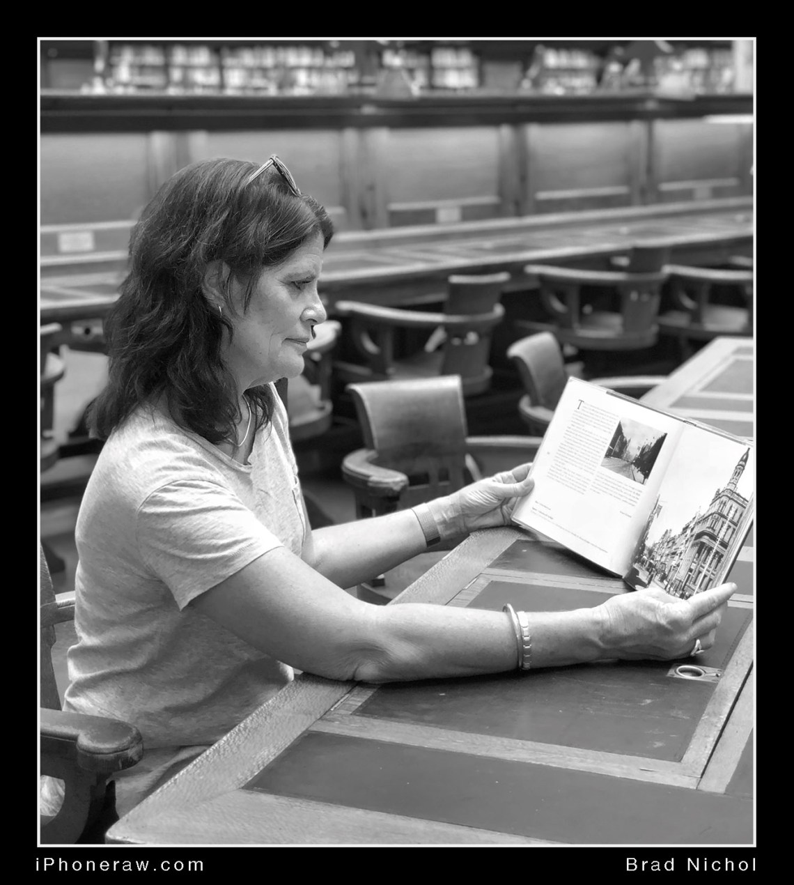 Lady in library, Victoria state library, iPhone X portrait mode, blurred foreground to match background, monochrome.